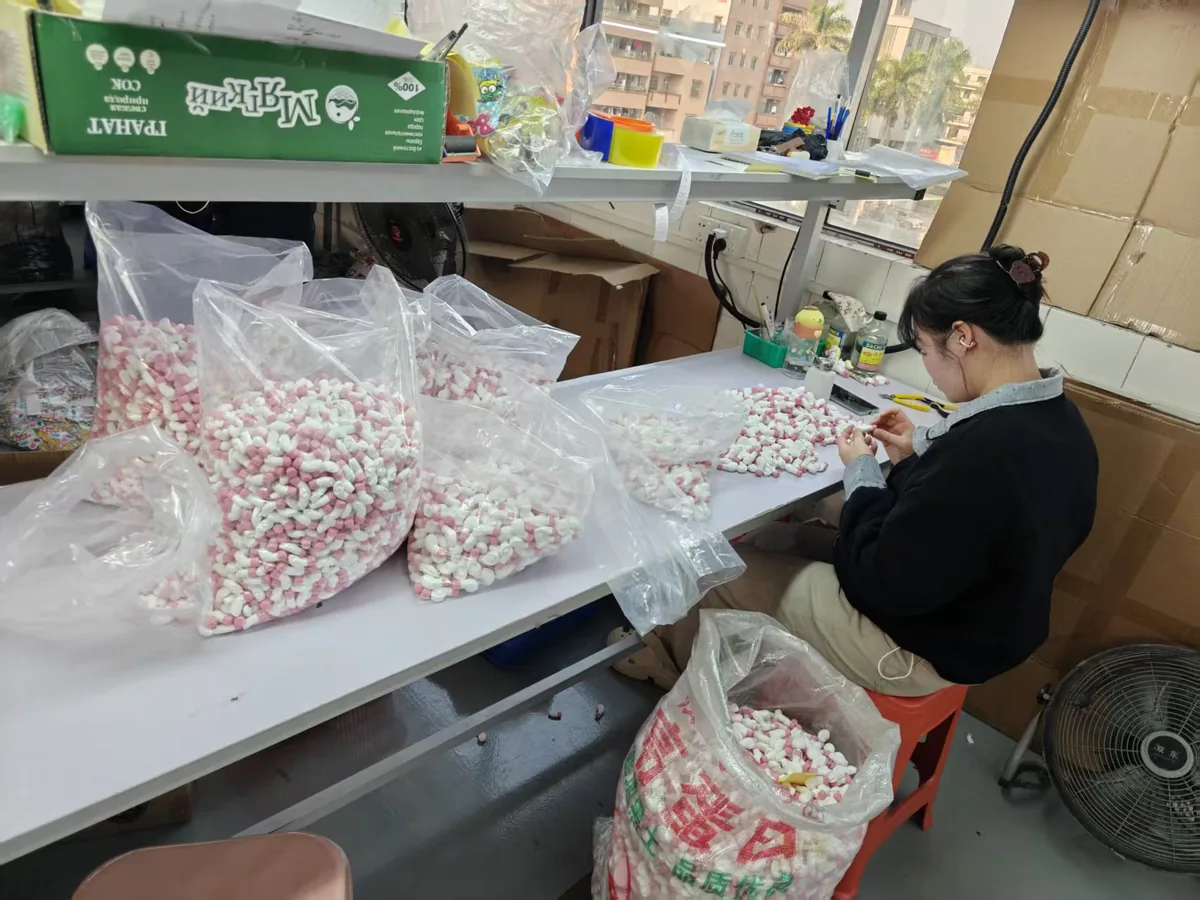 Hand-finishing small parts at a production bench in China